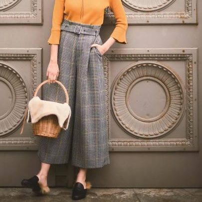 マスタードトップスにグレンチェックのワイドパンツを履いた女性