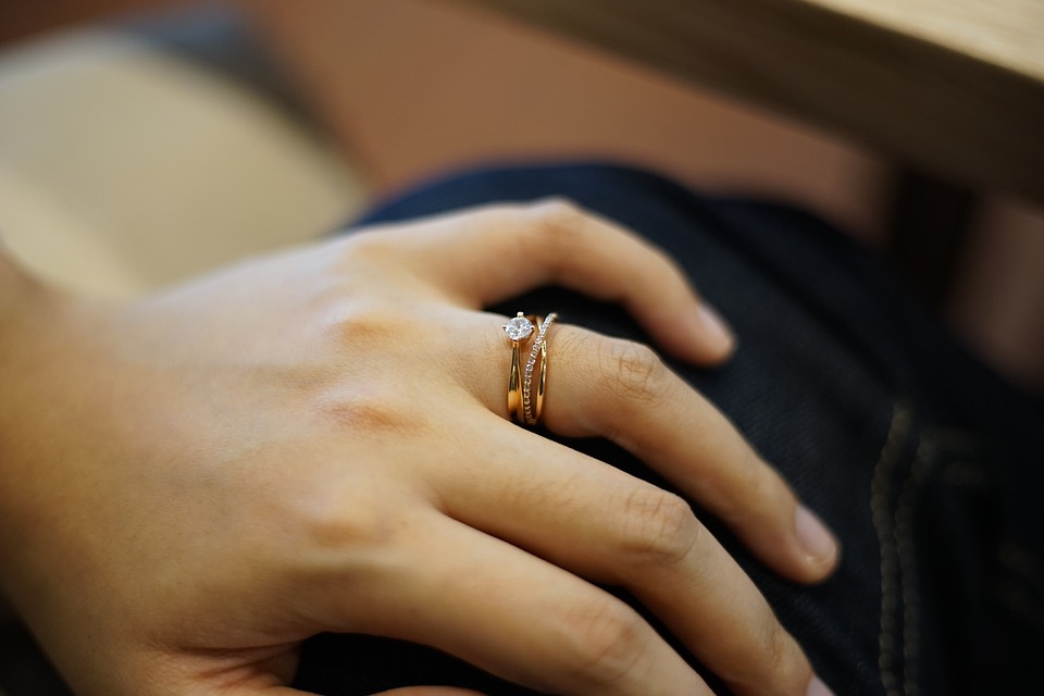 左手薬指にダイヤのリングと指輪を重ねづけしている女性