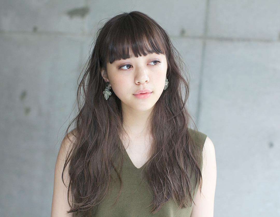 ぱっつん前髪の前髪あり黒髪ロングヘアスタイルの髪型の女性