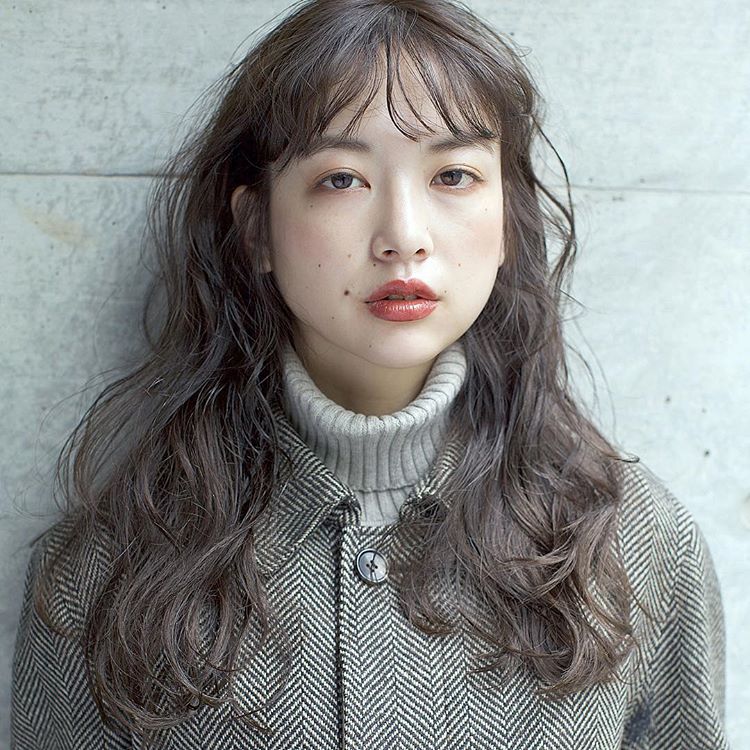 シースルーバングの前髪あり黒髪ロングウェーブヘアスタイルの髪型の女性