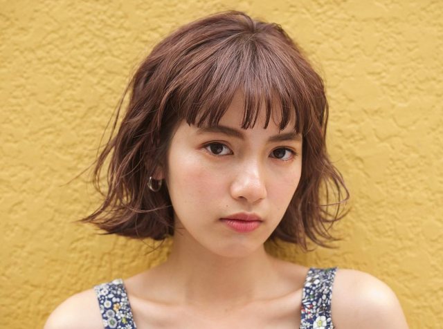 アラサー女子に似合う髪型のぱっつん前髪パーマボブヘアスタイルにした女性の画像