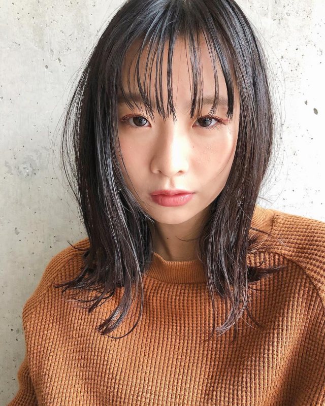 シースルー前髪ありの黒髪ストレートロングヘアスタイルにした丸顔の女性の画像