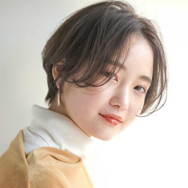 丸顔さんに似合う髪型の前髪なしの黒髪ショートヘアスタイルにした女性の画像