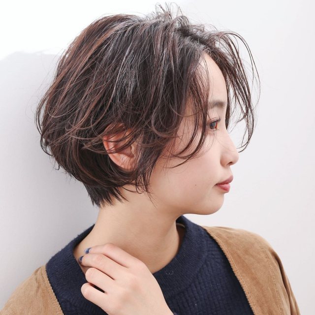 丸顔さんに似合う髪型の前髪なしのショートボブヘアスタイルにした女性が黒トップスを着た画像