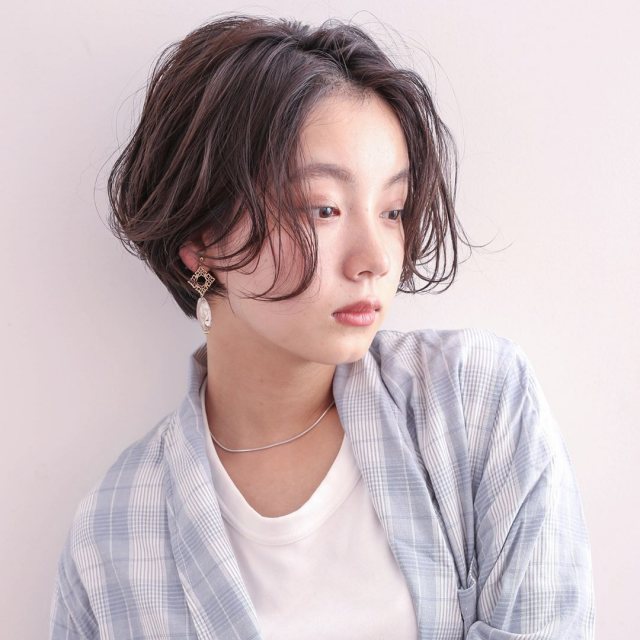 丸顔さんに似合う髪型の前髪なしのパーマショートボブヘアスタイルにした女性の画像