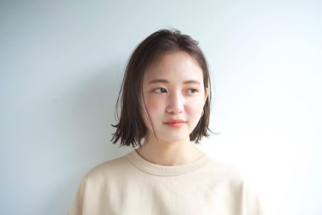 丸顔さんに似合う髪型の前髪なしのストレート外ハネボブヘアスタイルにした女性の画像