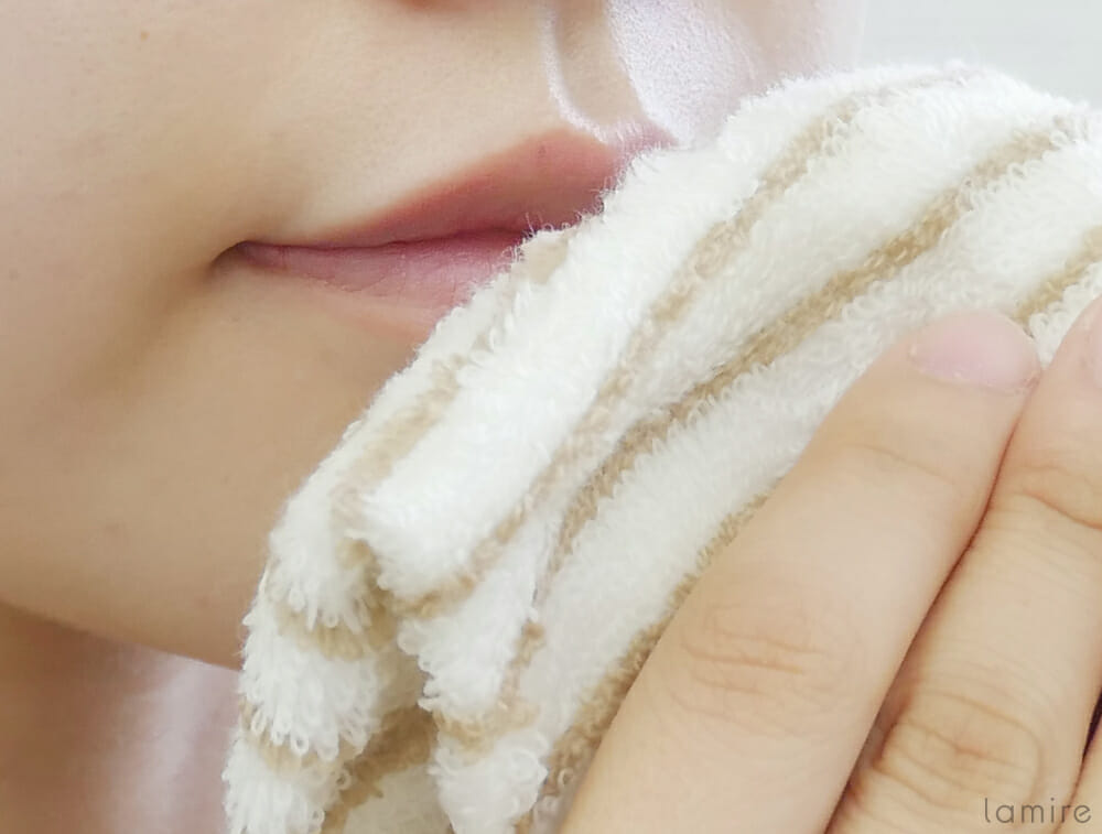 ホットタオルを使って、唇を温めている女性