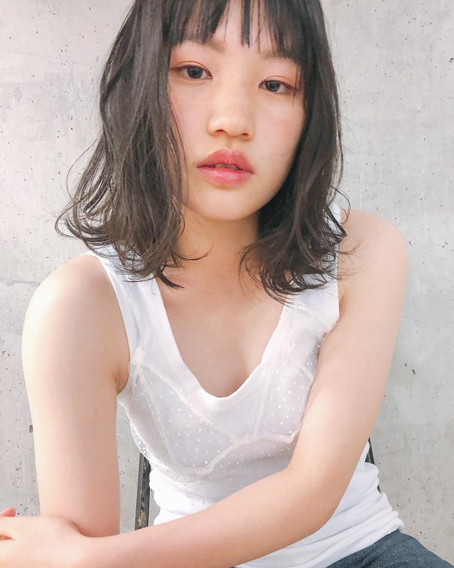 ミディアムボブヘアスタイルを無造作にセットした巻き方の女性の画像