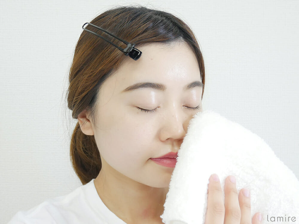 洗顔後、顔の水分を拭き取っている女性