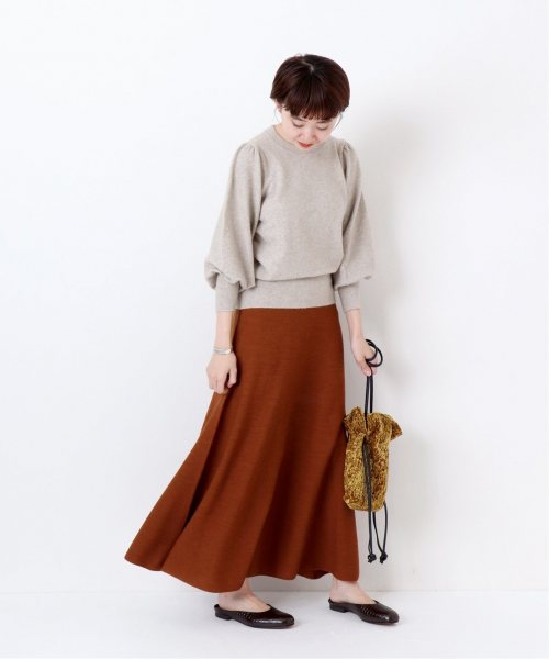 レンガ色のフレアスカートに似合う色のベージュニットを合わせたレディース秋冬コーディネート