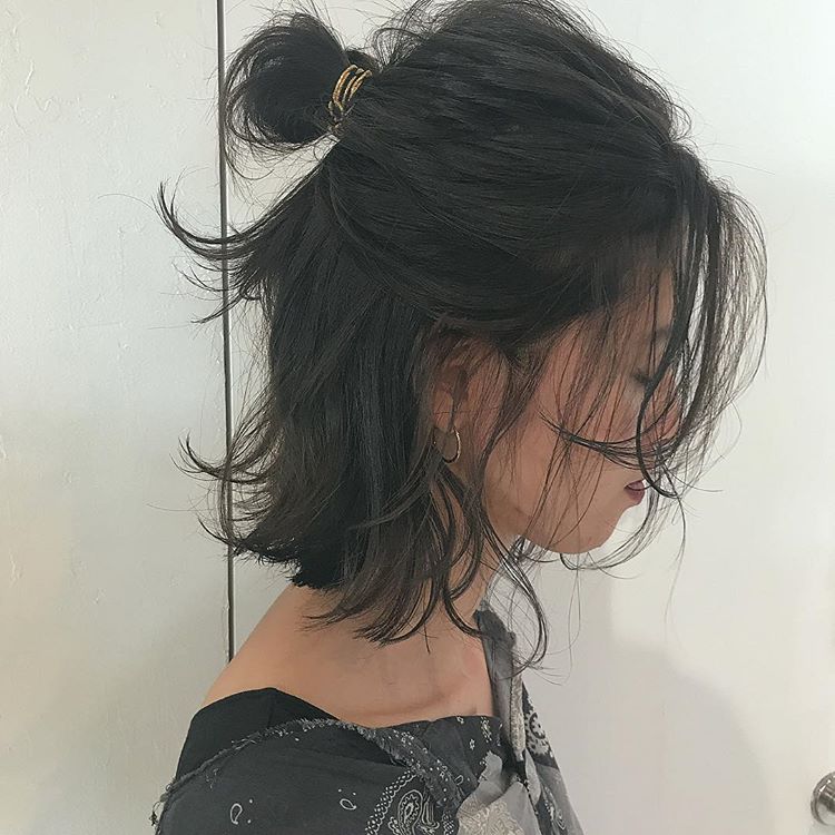 前髪なしの切りっぱなし黒髪ボブヘアの髪型をお団子ハーフアップにヘアアレンジしている女性