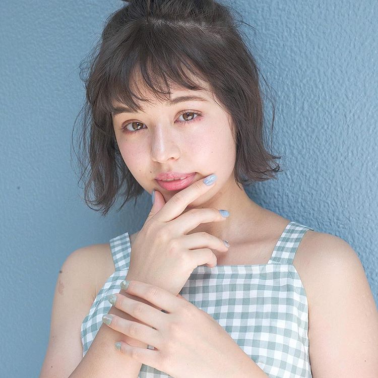 前髪ありの黒髪ショートボブヘアの髪型をストレートハーフアップにヘアアレンジしている女性