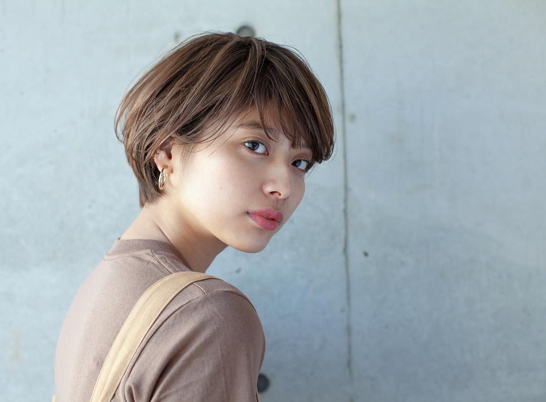 ベース型の輪郭をカバーしつつ小顔に見せてくれる斜めわけの前髪にした女性の画像