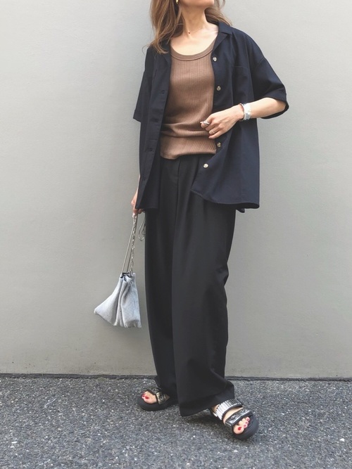 黒いパンツにシャツをきた女性