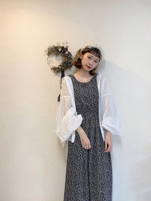 黒い小花柄のワンピースに白いシアーなシャツを合わせたコーデ