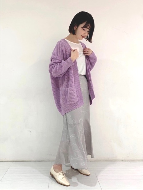 ざっくりニットカーディガンとTシャツとスカートを着た女性