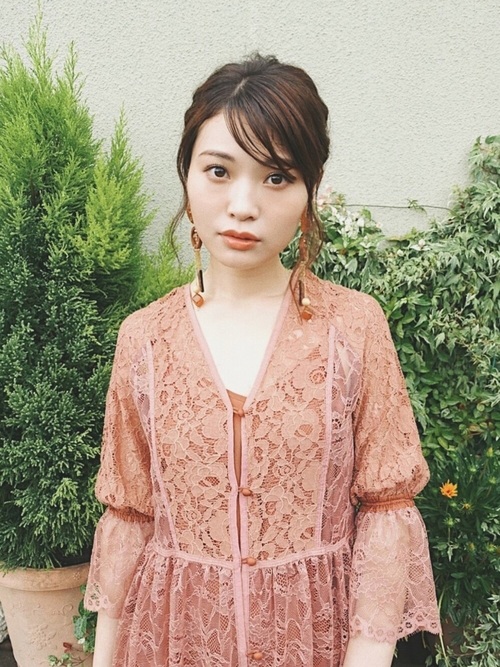 花柄総レースくすみピンクワンピを着て大ぶりピアスをつけ、真正面に立って上半身だけ写る女性
