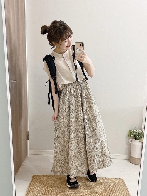 シャツと花柄スカートをリュックを着用した女性