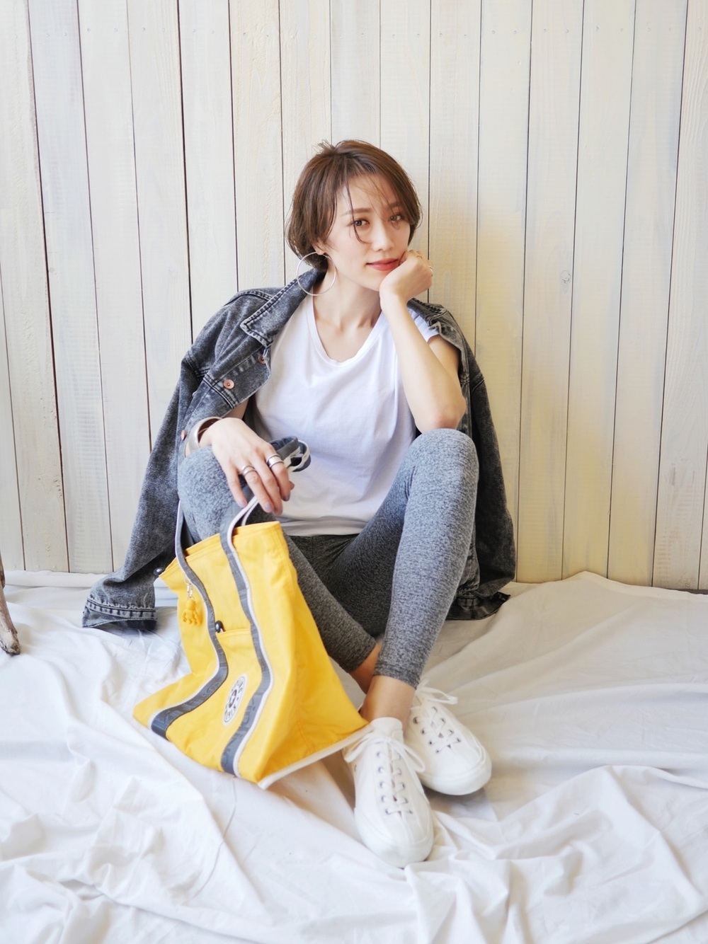白トップス、グレーのレギンスに白スニーカーを合わせる女性