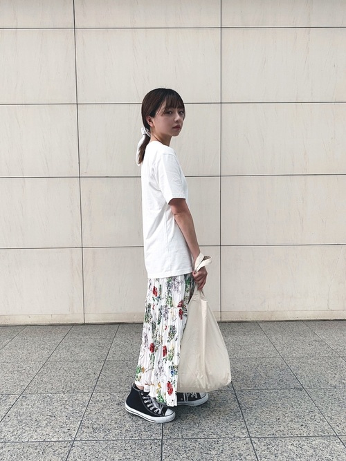 白の半袖Tシャツに白ベースの柄ロングスカートを合わせ、ポニーテールにスカーフを巻いたコーデ