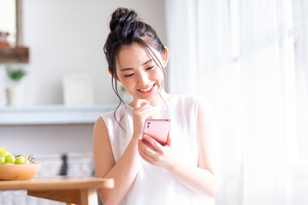 スマホを笑顔でチェックする女性