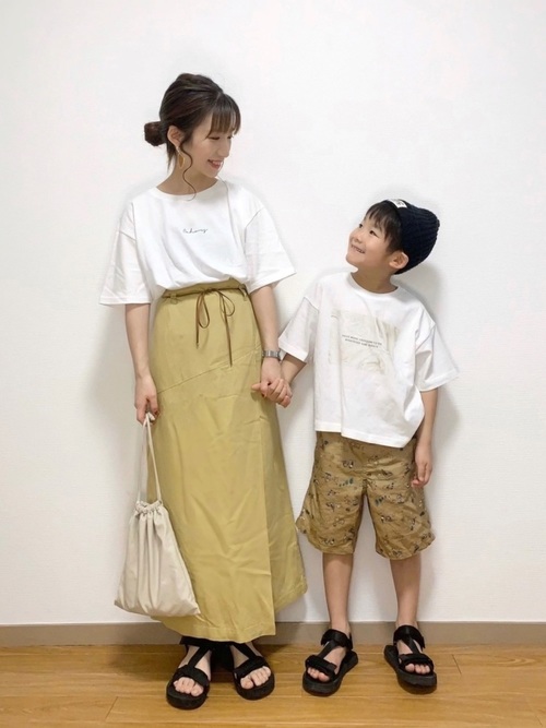 白ログプリントTシャツにイエロー切替えタイトスカートを履いた女性