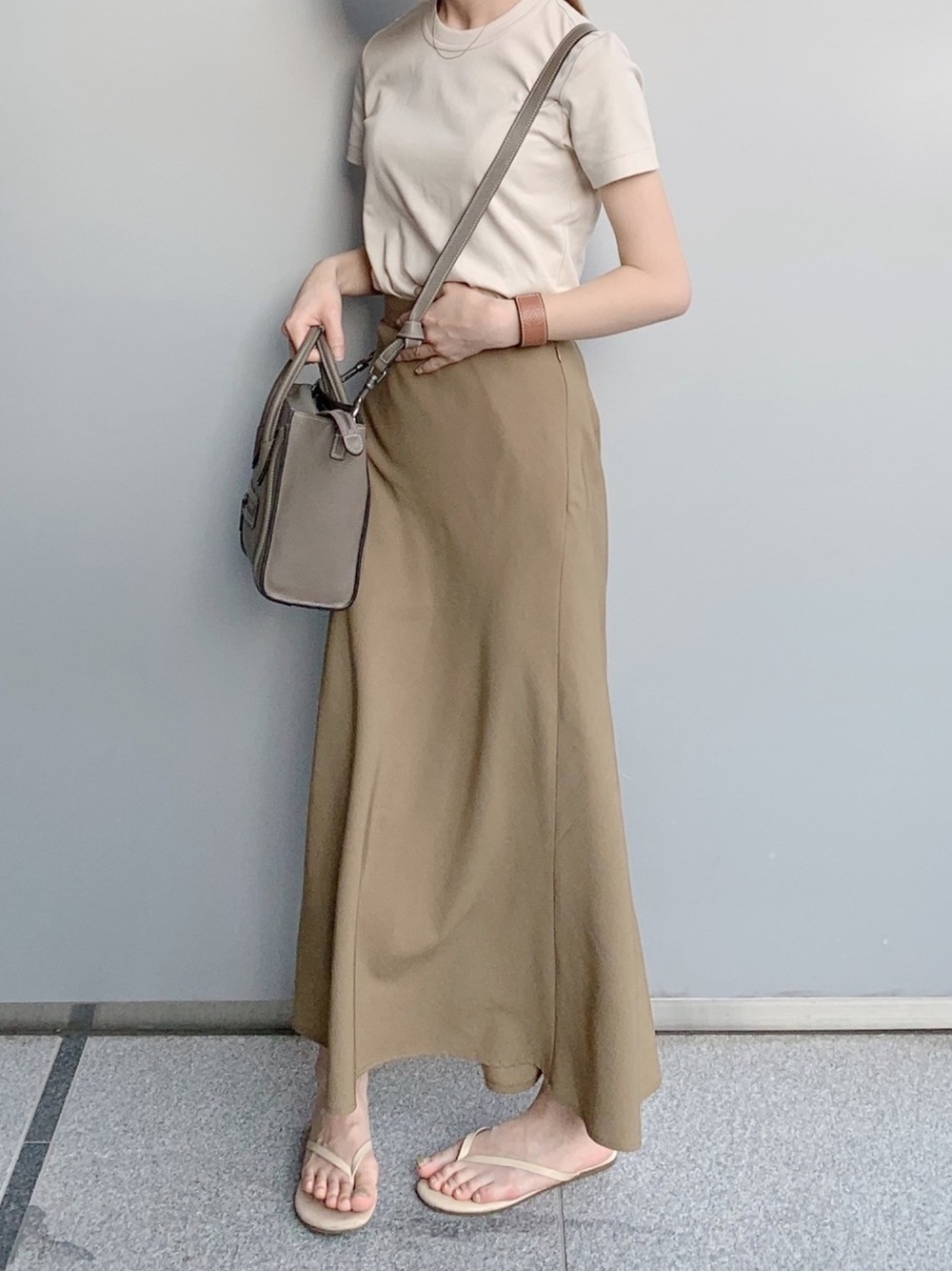 ユニクロのベージュTシャツにベージュのロングスカートを履いた女性