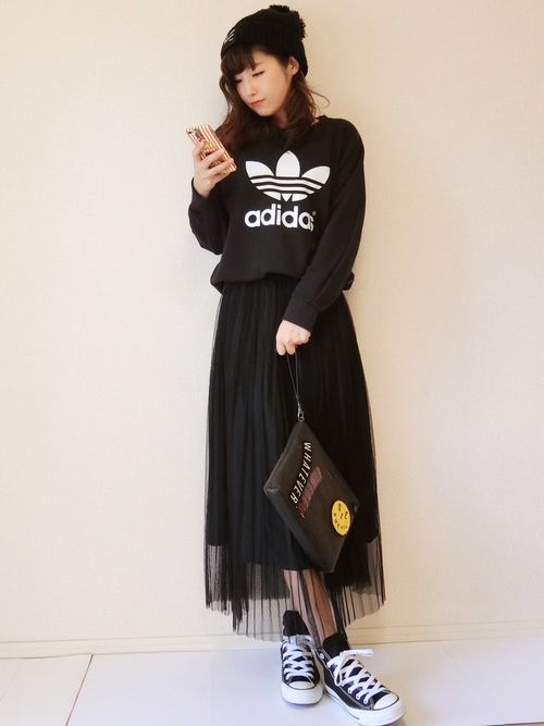 黒スウェットトレーナーにチュールプリーツスカートを履いた女性