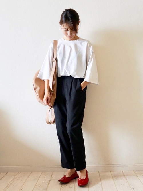 ベージュレザーリュックとオーバーサイズホワイトTシャツと赤パンプスのリュックコーデの女性