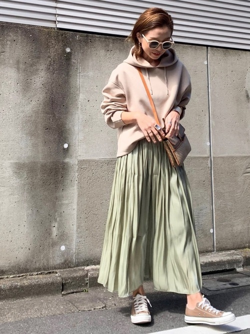 ベージュドライソフトスウェットプルパーカとシャイニーサテン×チュール リバーシブルスカートにベージュスニーカーを履いた女性