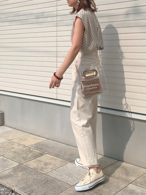 白コンバーススニーカーと白デニムパンツにドットノースリーブを着た女性
