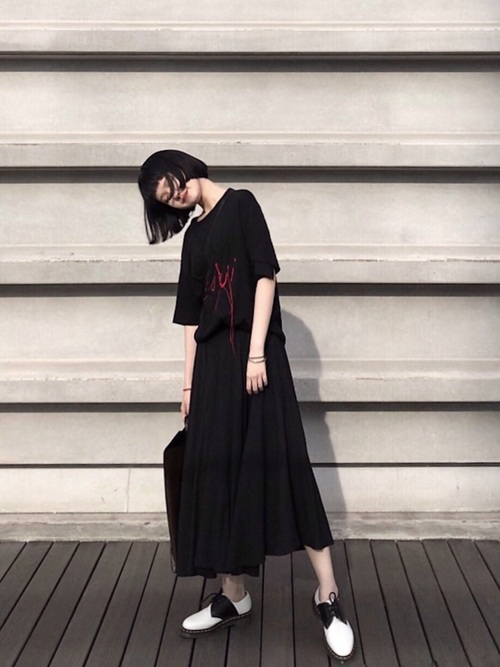 ヨウジヤマモトの黒Tシャツと黒ミモレ丈スカートと白ローファーコーデの女性
