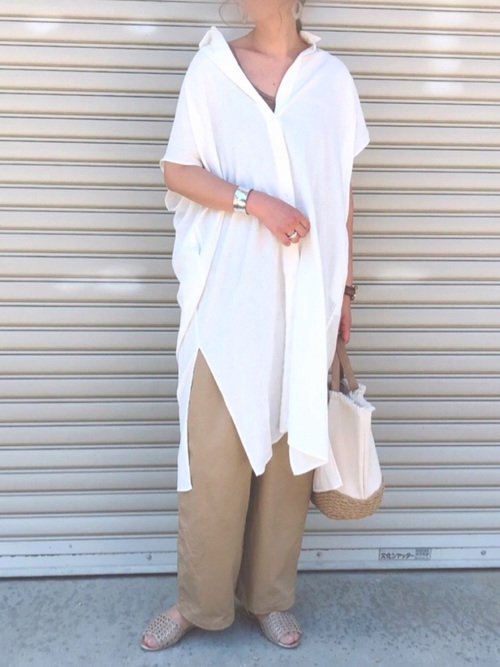白リネンブレンドロングシャツとベージュチノワイドパンツとゴールドオープントゥセパレートシューズのトップスコーデの女性