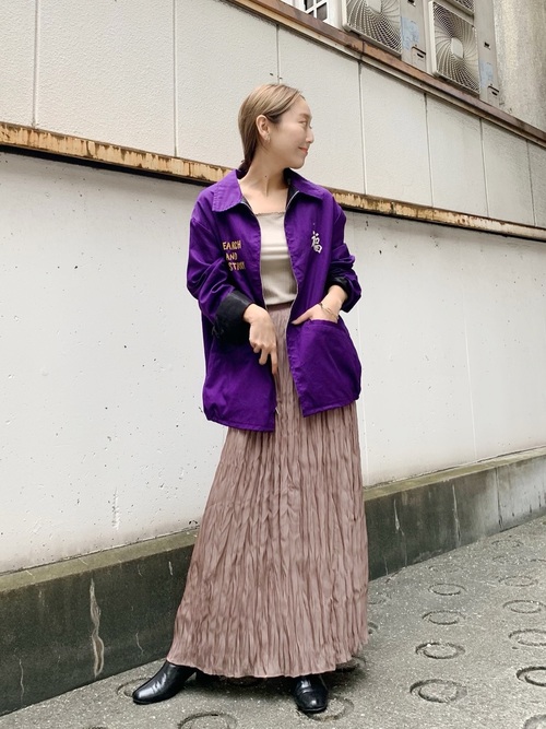 パープルベトジャンとフィラメントサテンスカートに黒革ブーツを履いた女性
