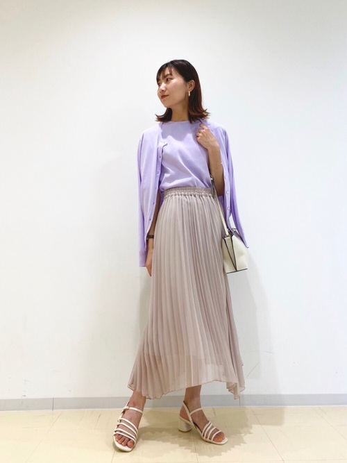 ラベンダークルーネックカーデとアイボリープリーツロングスカートにストラップサンダルを履いた女性