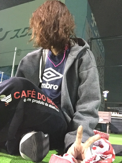 青ロゴ入りTシャツとグレーフード付パーカーに黒トレーニングパンツを履いた女性
