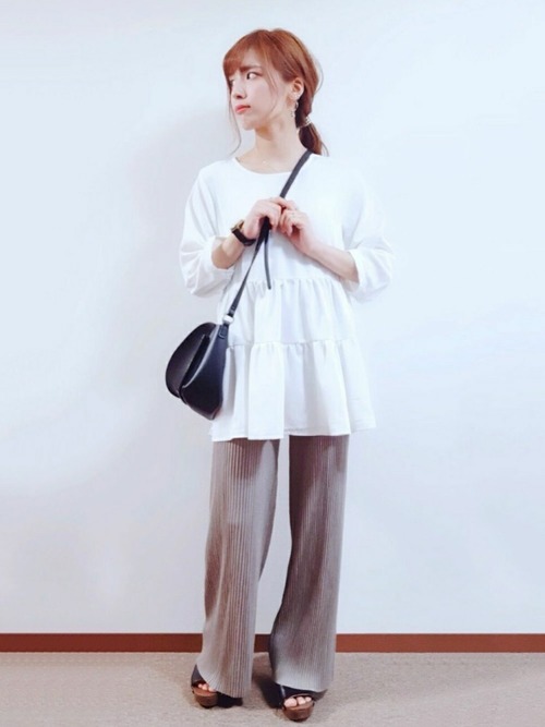 イージーリブパンツとティアードブラウスにウッドヒールサンダルを履いた女性