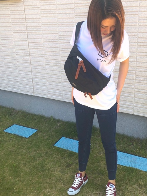 ルーカの白プリントTシャツとデニムスウェットイージーパンツに赤キャンパススニーカーを履いた女性