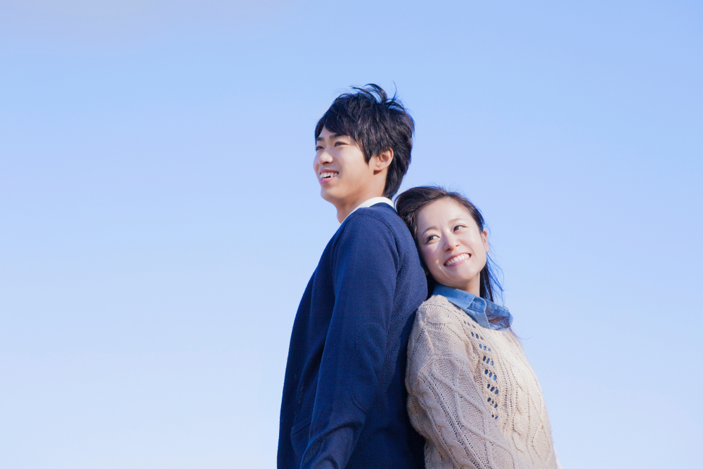 背中を合わせて立つ男女
