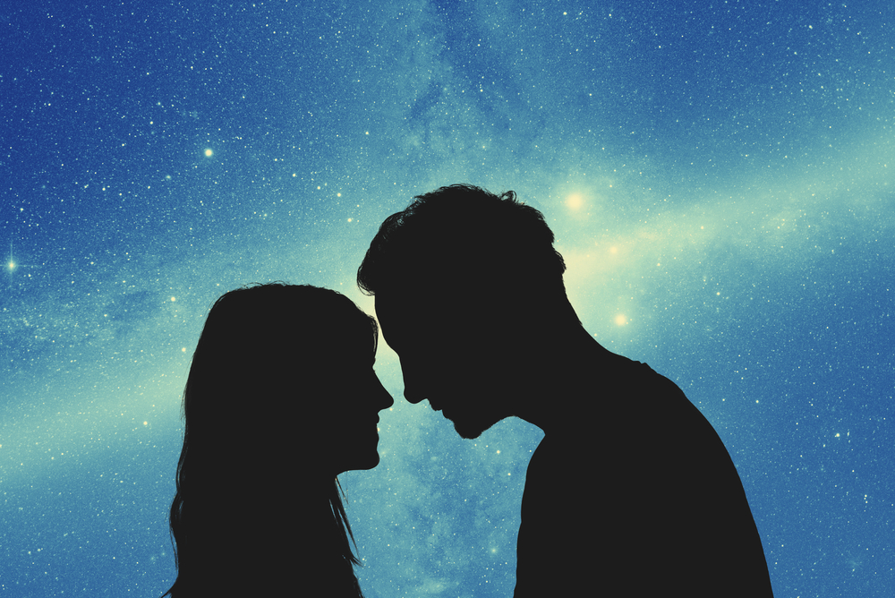 星空の下の若い夫婦のシルエット