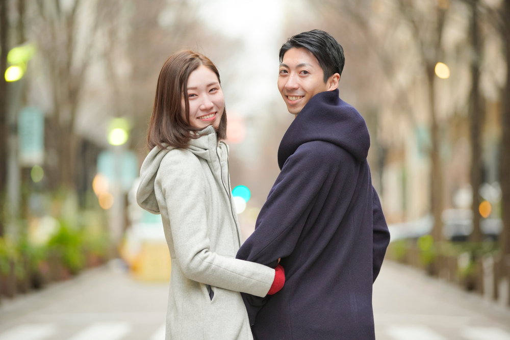 腕を組んで歩く男女