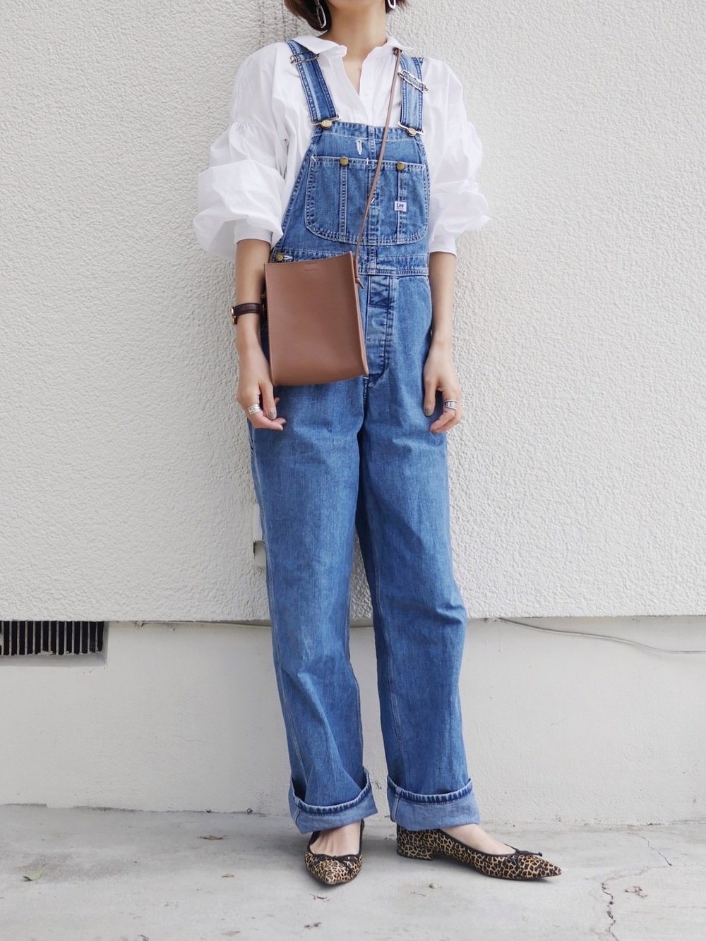 ZARAのシャツにデニムサロペットを合わせた女性