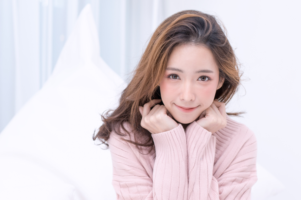 両手に顎を乗せて笑顔を見せる女性