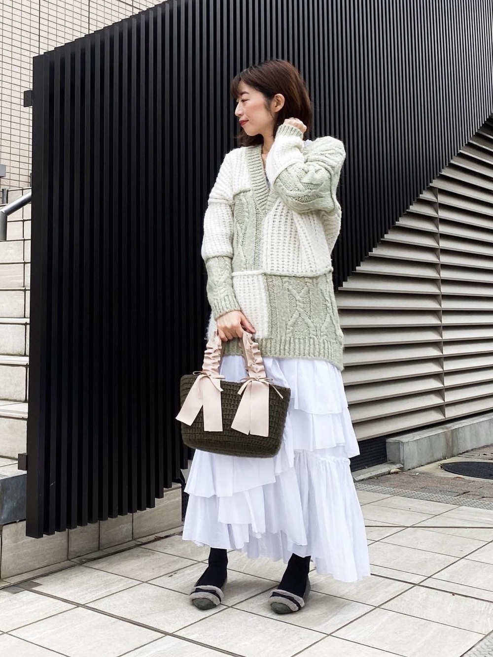 緑×白のニットを着た女性