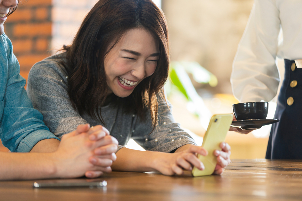 スマホを見ながら楽しそうな女性