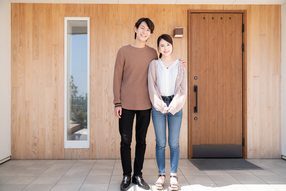 玄関前に立つ男女
