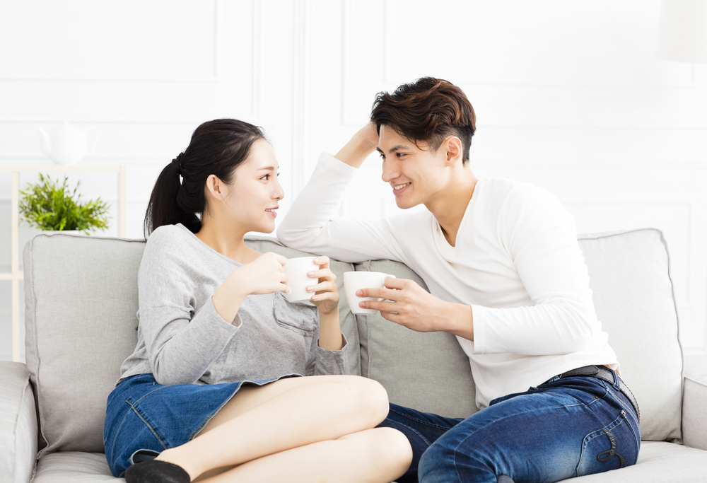 ソファーに座って会話するカップル