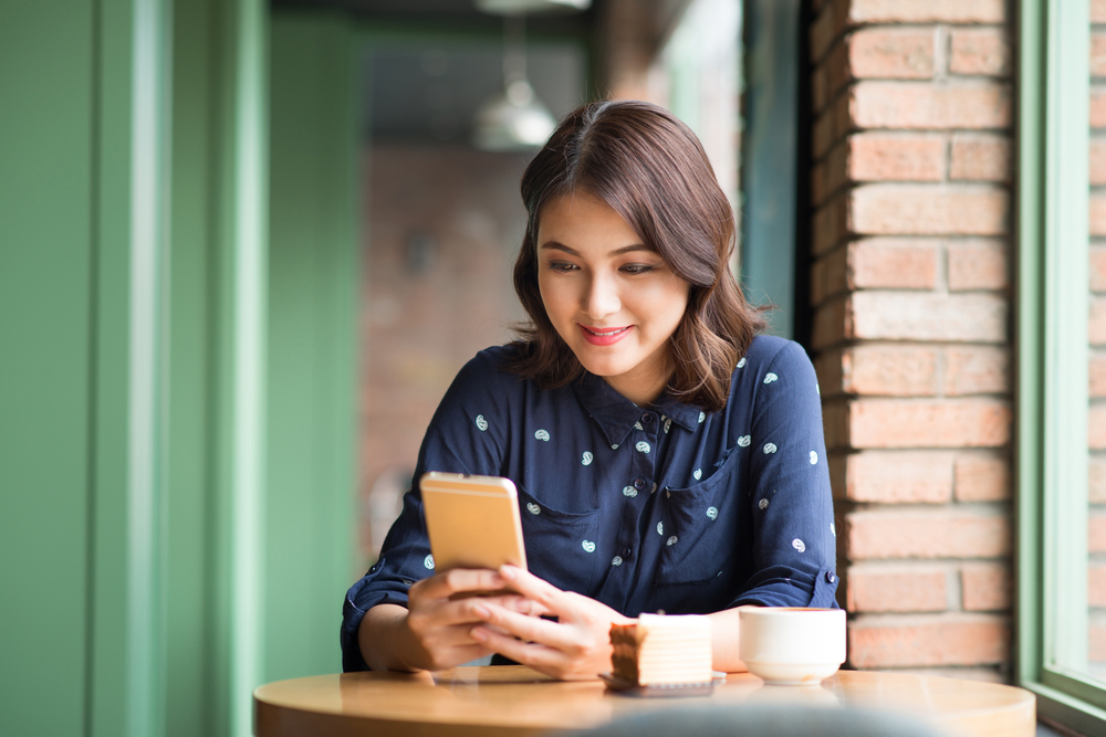 カフェでスマホを触る女性