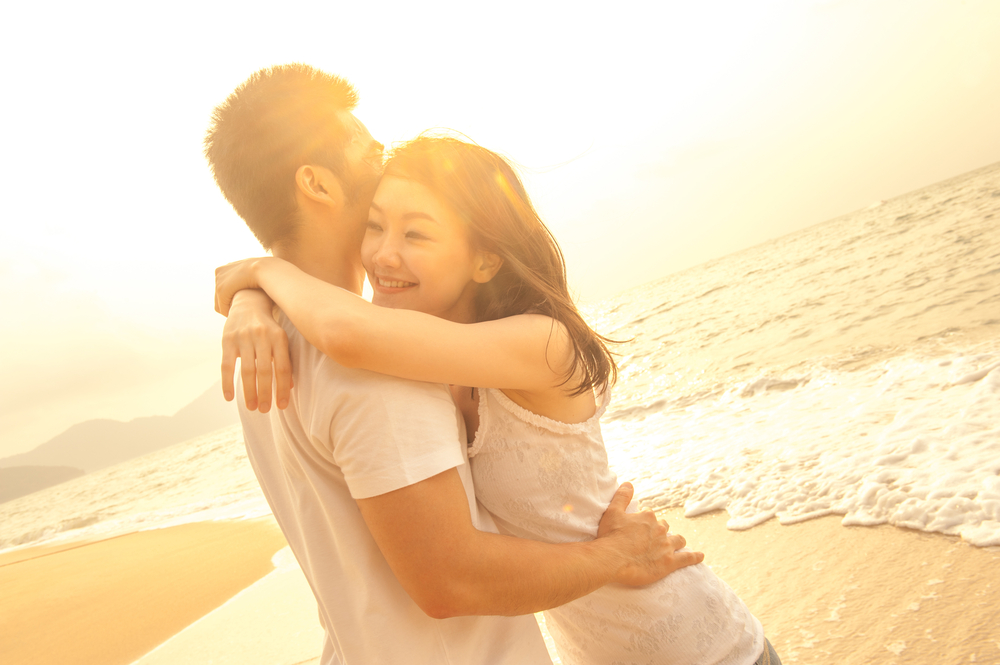 海辺で抱き合うカップル