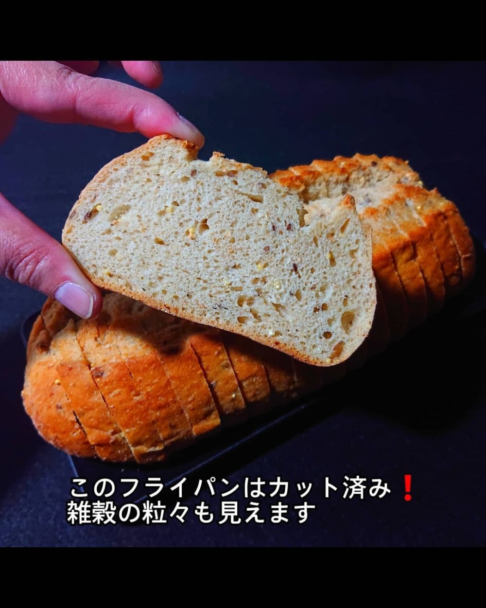 業務スーパーのフランスパンを一切れ手に持っている写真